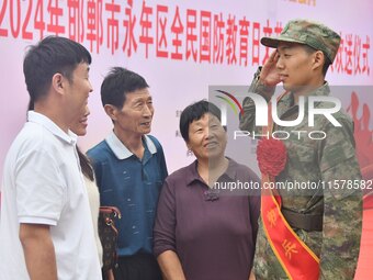 A new recruit salutes his family at a militia training base in Yongnian district of Handan, China, on September 14, 2024. (