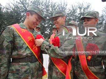 A recruit wears a red flower for his comrades at a militia training base in Yongnian district in Handan, China, on September 14, 2024. (