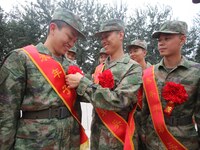 A recruit wears a red flower for his comrades at a militia training base in Yongnian district in Handan, China, on September 14, 2024. (