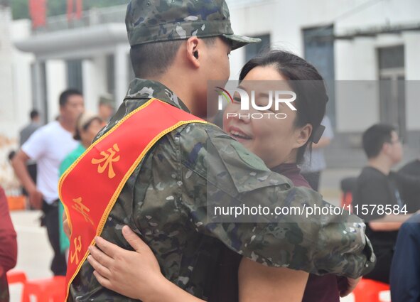 A mother embraces her son who joins the army at a militia training base in Yongnian district of Handan, China, on September 14, 2024. 