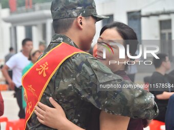 A mother embraces her son who joins the army at a militia training base in Yongnian district of Handan, China, on September 14, 2024. (