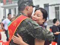 A mother embraces her son who joins the army at a militia training base in Yongnian district of Handan, China, on September 14, 2024. (