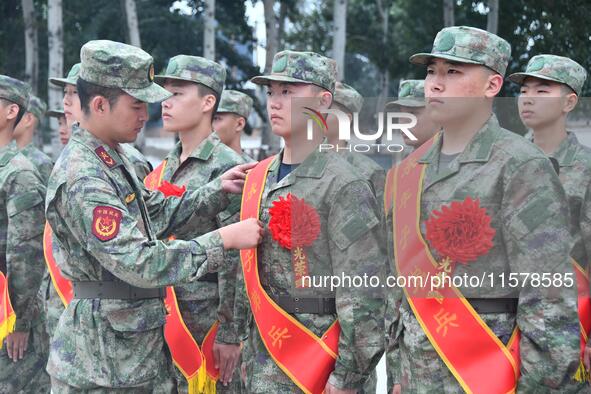 A staff member arranges ribbons for new recruits at the militia training base in Yongnian district of Handan, in Handan, China, on September...