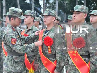 A staff member arranges ribbons for new recruits at the militia training base in Yongnian district of Handan, in Handan, China, on September...