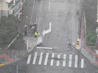 A sanitation worker cleans an urban sewer to prevent water from flooding at a junction in Yangpu district in Shanghai, China, on September 1...