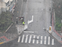 A sanitation worker cleans an urban sewer to prevent water from flooding at a junction in Yangpu district in Shanghai, China, on September 1...