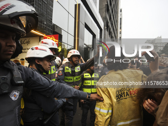 Protesters hold a demonstration against the fires and the climate situation in Brazil and for agrarian reform on Avenida Paulista, in the ce...