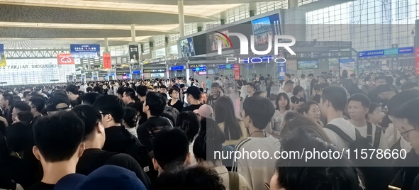 A large number of tourists prepare to travel at Chengdu East Railway Station on the first day of the Mid-Autumn Festival holiday in Chengdu,...