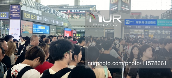 A large number of tourists prepare to travel at Chengdu East Railway Station on the first day of the Mid-Autumn Festival holiday in Chengdu,...