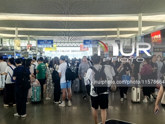 A large number of tourists prepare to travel at Chengdu East Railway Station on the first day of the Mid-Autumn Festival holiday in Chengdu,...