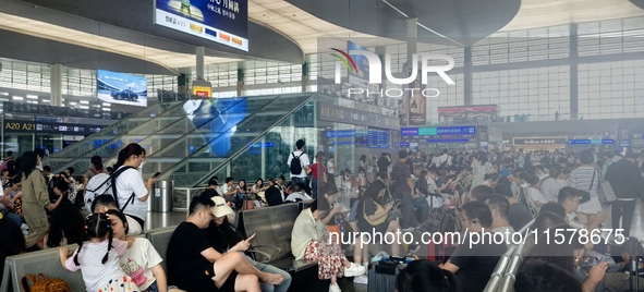 A large number of tourists prepare to travel at Chengdu East Railway Station on the first day of the Mid-Autumn Festival holiday in Chengdu,...