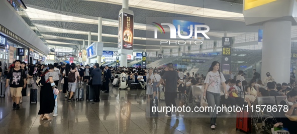 A large number of tourists prepare to travel at Chengdu East Railway Station on the first day of the Mid-Autumn Festival holiday in Chengdu,...