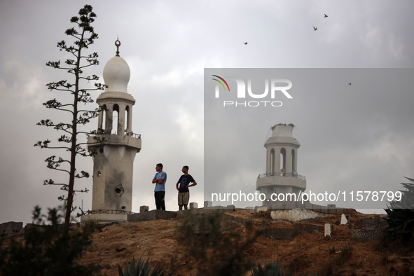 Palestinians stand inside a cemetery in the Nuseirat refugee camp in the central Gaza Strip, on September 16, 2024, amid the ongoing war bet...