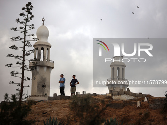 Palestinians stand inside a cemetery in the Nuseirat refugee camp in the central Gaza Strip, on September 16, 2024, amid the ongoing war bet...