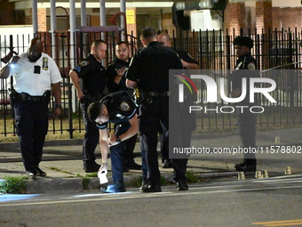 Police place evidence markers and set up crime scene tape at the scene where two people are shot. Two people are shot in Brooklyn, New York,...