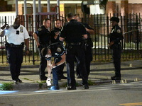 Police place evidence markers and set up crime scene tape at the scene where two people are shot. Two people are shot in Brooklyn, New York,...