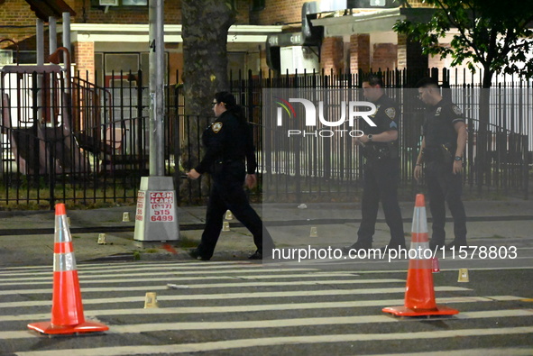 Police place evidence markers and set up crime scene tape at the scene where two people are shot. Two people are shot in Brooklyn, New York,...