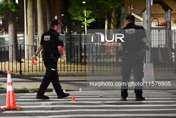 Police place evidence markers and set up crime scene tape at the scene where two people are shot. Two people are shot in Brooklyn, New York,...