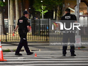 Police place evidence markers and set up crime scene tape at the scene where two people are shot. Two people are shot in Brooklyn, New York,...