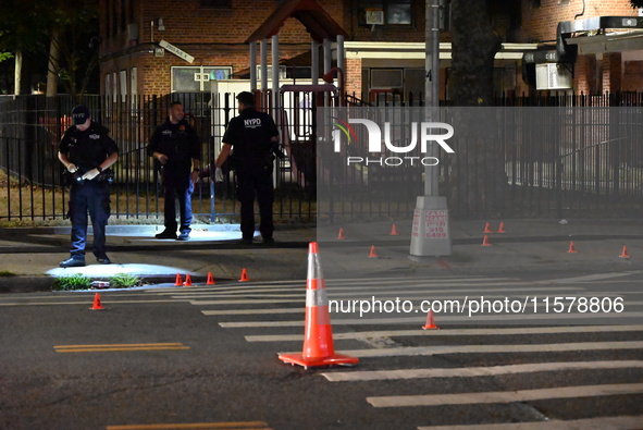 Police place evidence markers and set up crime scene tape at the scene where two people are shot. Two people are shot in Brooklyn, New York,...