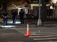 Police place evidence markers and set up crime scene tape at the scene where two people are shot. Two people are shot in Brooklyn, New York,...