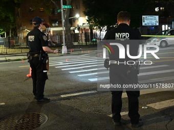 Police place evidence markers and set up crime scene tape at the scene where two people are shot. Two people are shot in Brooklyn, New York,...