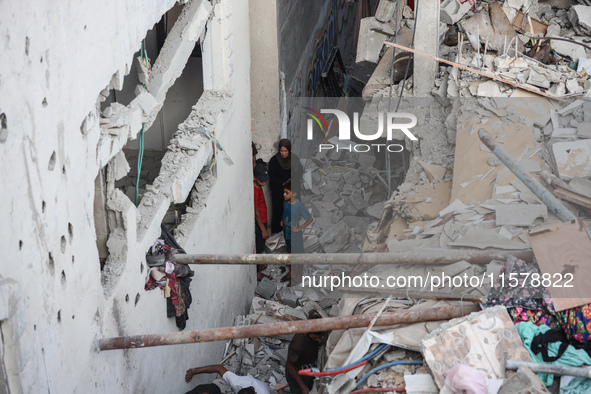 Palestinians inspect a house hit in an Israeli strike in Nuseirat, Gaza Strip, on September 16, 2024, amid the ongoing war between Israel an...