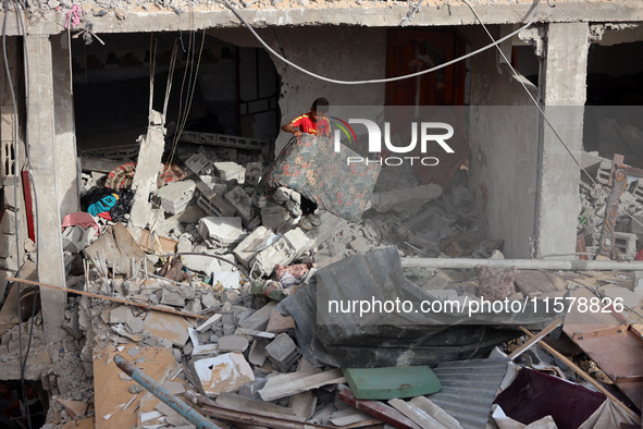 A Palestinian boy inspects his home, which is damaged by an Israeli airstrike on a house in Nuseirat, central Gaza Strip, on September 16, 2...