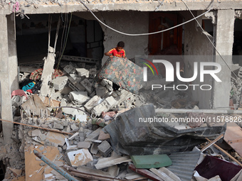 A Palestinian boy inspects his home, which is damaged by an Israeli airstrike on a house in Nuseirat, central Gaza Strip, on September 16, 2...