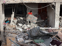 A Palestinian boy inspects his home, which is damaged by an Israeli airstrike on a house in Nuseirat, central Gaza Strip, on September 16, 2...