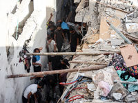 Palestinians inspect a house hit in an Israeli strike in Nuseirat, Gaza Strip, on September 16, 2024, amid the ongoing war between Israel an...