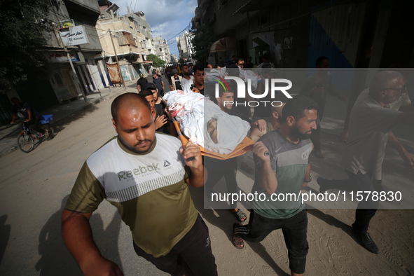 Mourners carry the bodies of members of the Al-Qassas family during their funeral in the Nuseirat refugee camp for Palestinian refugees in c...