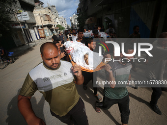 Mourners carry the bodies of members of the Al-Qassas family during their funeral in the Nuseirat refugee camp for Palestinian refugees in c...