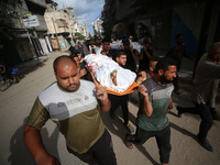 Mourners carry the bodies of members of the Al-Qassas family during their funeral in the Nuseirat refugee camp for Palestinian refugees in c...