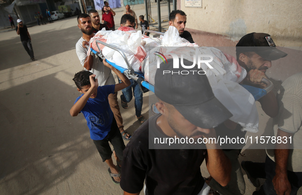 Mourners carry the bodies of members of the Al-Qassas family during their funeral in the Nuseirat refugee camp for Palestinian refugees in c...