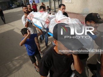 Mourners carry the bodies of members of the Al-Qassas family during their funeral in the Nuseirat refugee camp for Palestinian refugees in c...