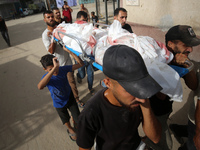 Mourners carry the bodies of members of the Al-Qassas family during their funeral in the Nuseirat refugee camp for Palestinian refugees in c...