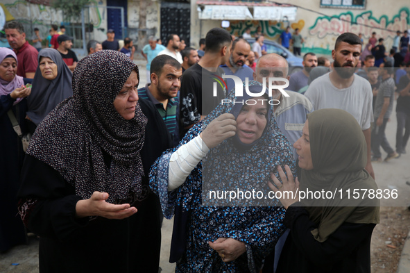 Mourners wait to bury the bodies of members of the Al-Qassas family in the cemetery in the Nuseirat refugee camp for Palestinian refugees in...