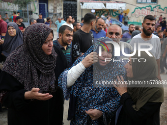 Mourners wait to bury the bodies of members of the Al-Qassas family in the cemetery in the Nuseirat refugee camp for Palestinian refugees in...