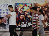 People walk past movie posters at a cinema in Fuyang, China, on September 16, 2024. (