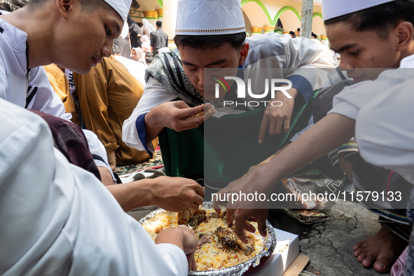 Muslims eat kebuli rice during the Prophet Muhammad's birthday celebration in Tangerang, Banten Province, Indonesia, on September 16, 2024....