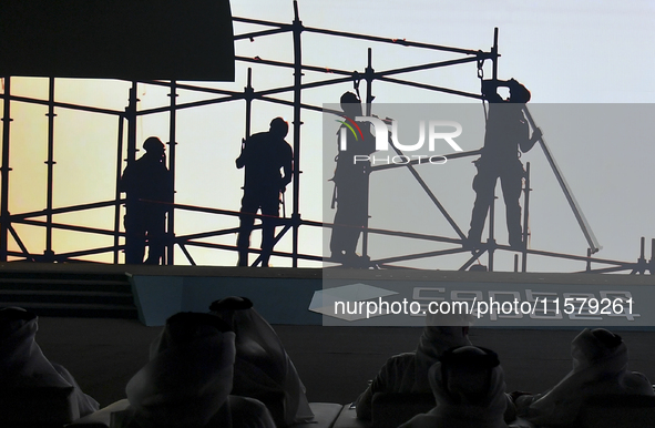 People look at display screens during the opening of the ConteQ Expo24 (Advanced Technology for Construction & Services Expo) at the Qatar N...