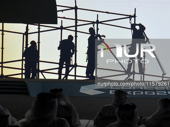 People look at display screens during the opening of the ConteQ Expo24 (Advanced Technology for Construction & Services Expo) at the Qatar N...