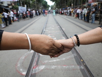 Teachers make a human chain during a protest against the rape and murder of a PGT woman doctor at the government-run R G Kar Medical College...