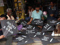 Kite-maker Ajit Dutta (L) displays kites printed with 'Justice for RG Kar' for sale at a shop to protest after the rape and murder of a PGT...