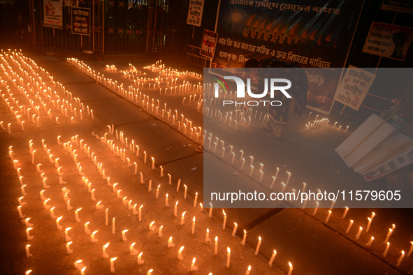 Former students of Ramkrishna Mission light candles as they take part in a protest to condemn the rape and murder of a young medic at RG Kar...