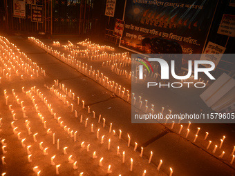 Former students of Ramkrishna Mission light candles as they take part in a protest to condemn the rape and murder of a young medic at RG Kar...