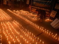 Former students of Ramkrishna Mission light candles as they take part in a protest to condemn the rape and murder of a young medic at RG Kar...