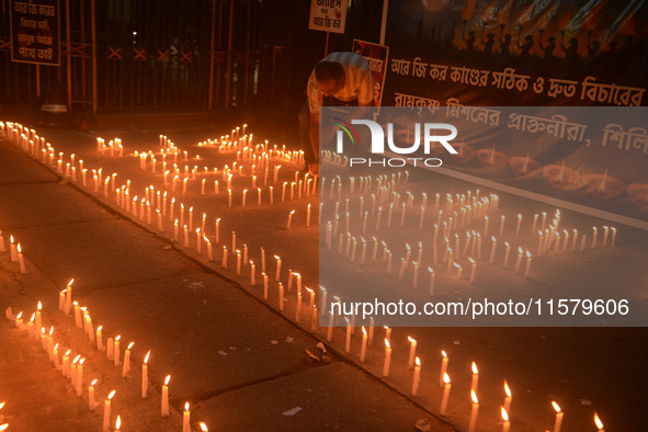 Former students of Ramkrishna Mission light candles as they take part in a protest to condemn the rape and murder of a young medic at RG Kar...