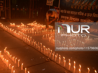 Former students of Ramkrishna Mission light candles as they take part in a protest to condemn the rape and murder of a young medic at RG Kar...